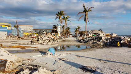 Fototapeta na wymiar A month after Hurricane Ian brought historic winds and storm surge to the island of Fort Myers Beach, rubble still sits in piles near the shore. 