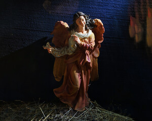 Fototapeta na wymiar wax Christmas figurine of Gloria Angel on a dark background