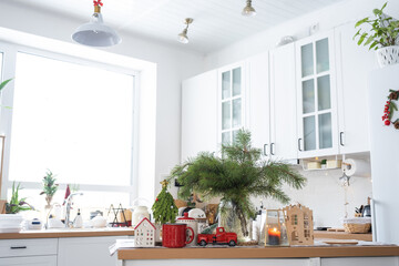 Festive Christmas decor in white kitchen, festive breakfast, white scandi interior. The figure of a cozy house ion the set table. New Year, mood, cozy home. Copy space