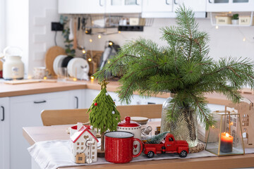 Key to the house on cozy home with Christmas decor on table of festive kitchen. Gift for New Year. Building, design, project, moving to new house, mortgage, rent and purchase real estate