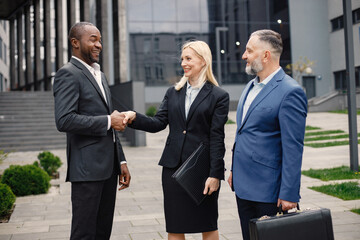 Business people standing and talk to each other in front of modern office