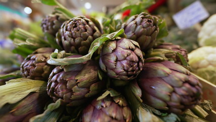 Obraz premium Fresh artichokes at farmers market. Closeup of organic food on display