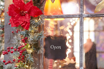 sign on the store with the inscription open. decorated with christmas decorations