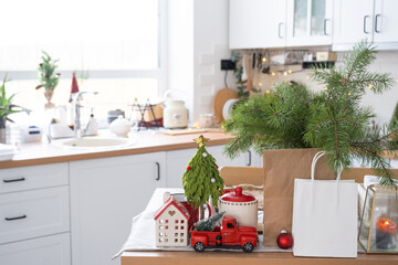 Paper packages mock up are on kitchen served table decorated for Christmas. Shopping and gifts, present and ready meals are delivered and prepared for the new year