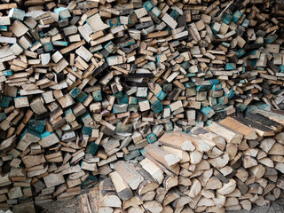 Dry firewood stacked in a pile, chopped wood for winter heating fuel of the fireplace. Natural wood background.