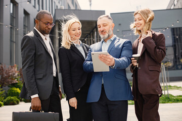 Business people standing and talk to each other in front of modern office