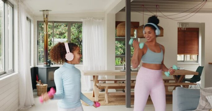 Mother, kid and workout in family home with dumbbells, music headphones and fun exercise tutorial in living room together. Mom, girl child and fitness in lounge for healthy lifestyle, body and energy