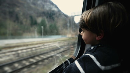 Obraz premium Contemplative kid staring at train window. One passenger child seated in contemplation. Pensive moody small boy traveling inside transportation in motion 3