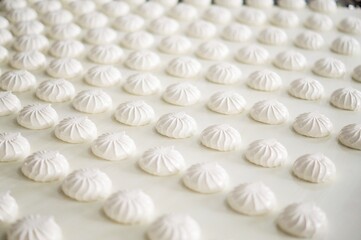 Food production. Marshmallow of white color moves along the conveyor