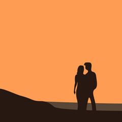 Silhouette of a lovely couple standing on the beach and watching sunset