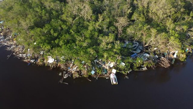 Debris from Hurricane Ian litters the waters of Fish Trap Bay on Bonita Beach, FL