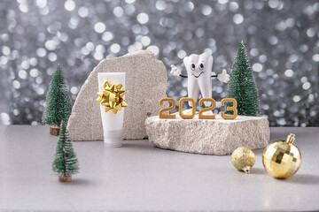 cartoon model of a tooth, the numbers 2023 on a podium made of stone, toothpaste and Christmas...