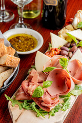 Charcuterie Board. Cheese Board Assortment on cured and salted deli meats and cheeses, pastrami, salami, prosciutto served with olives and dried fruits. Classic traditional party favorite.  