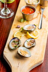 Oysters. Oysters on the half shell. Fresh oysters served with garlic, shallots, cocktail sauce, mignonette sauce and fresh lemons and limes. Classic American steakhouse or French bistro appetizer.