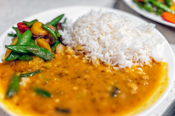 Macro closeup of orange curry healthy coconut squash dal Indian yellow split peas sauce food meal...