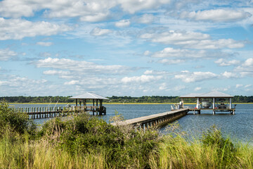 Island bay channel water of Matanzas River in Crescent Beach by Marineland, Florida with wooden docks pier and green grass marsh landscape view in north Florida coast