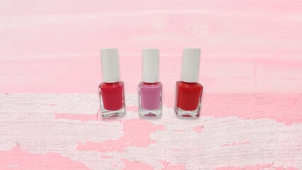 Three isolated nail polish on pink gradient background with texture