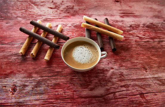cup with caffe latte with foam and eclairs with and without chocolate