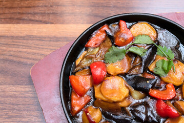Delicious asian food in cast-iron pan on wooden background. Selective focus. Asian food concept