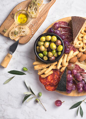 Appetizers boards with assorted  delicatessen cheese, salami, grape and nuts. Charcuterie and cheese platter, Spanish style and ingredients: olives, Pimientos, Chorizo, picos, cheese Semicurado - obrazy, fototapety, plakaty