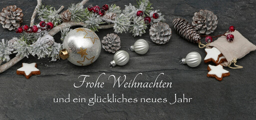 Weihnachtskarte: Weiße Weihnachtskugeln mit Zweigen auf einem Schieferhintergrund mit dem Text...