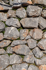 Stone wall. A fragment of a wall made of chipped stone. Background of old masonry. Stone wall texture