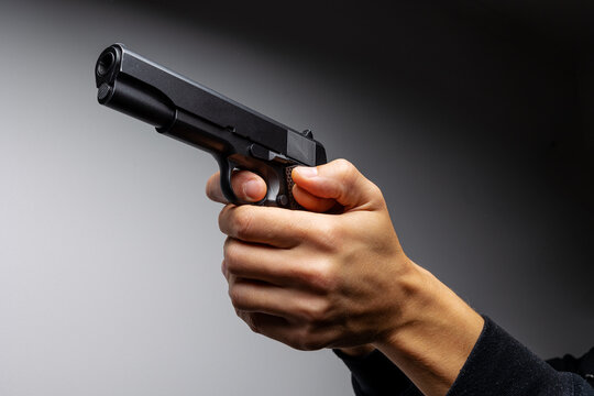 Close up of man hand with aiming gun.