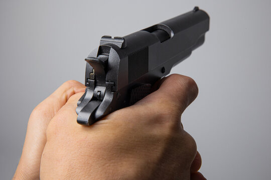 Close up of man hand with aiming gun on white background.