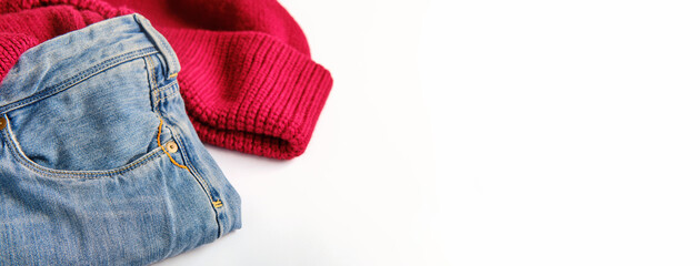 blue jeans and a burgundy sweater on a white background, copy space