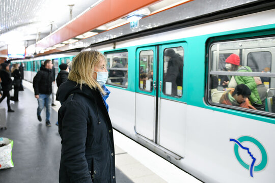 A Person (woman) Wearing A Surgical Blue Mask On Public Transport Due To The Covid-19 (coronavirus) Pandemic In The Parisian Subway.