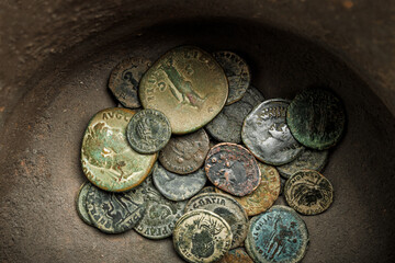 Ancient roman coins inside a ceramic jar.