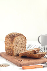 Fresh sliced rye bread with seeds on a wooden board. Breakfast with healthy bread. Copy space.
