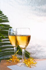 Beautiful champagne glasses with Christmas decorations and shiny silver background