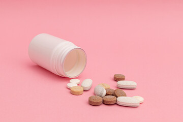 Medicine with pills on pink background
