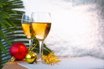 Beautiful champagne glasses with Christmas decorations and shiny silver background