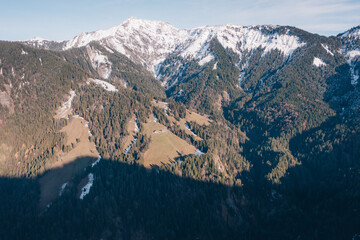 Luftaufnahmen von einem mit Fichtenwald bewaldeten Tal in den Alpen.