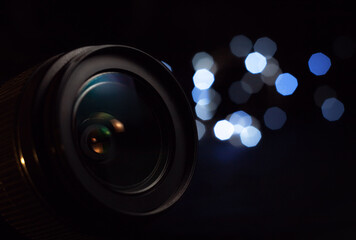 Camera lens close-up, lights out of focus on the background