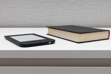 e-book lies on the table near paper books.