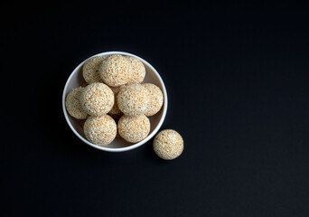Makar Sankranti festival, pile or stacked The indian sesame sweet Rajgira laddu made from Amaranth seed in Bowl black background