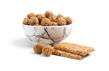 happy makar sankranti special Sesame seed ball called Till ke laddu in bowl isolated on white...