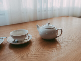 Still life with a white Teapot and teacup on wooden brown table