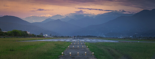 empty runway at sunset, mountains in the background