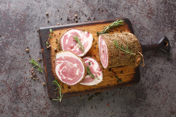Italian traditional bacon pancetta on a cutting board closeup on the table. Horizontal top view...