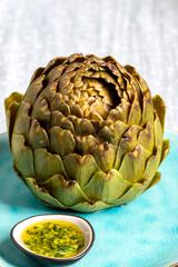 Obraz premium cooked artichoke on a blue plate