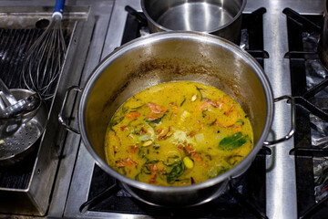 Vegetables in pots in the kitchen. Steel pots