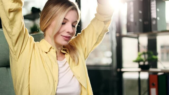 Charming blond office worker finish break stretching at sunny workplace and continue her computer pc work with enthusiasm Motivated young business woman relaxed returns to work indoors