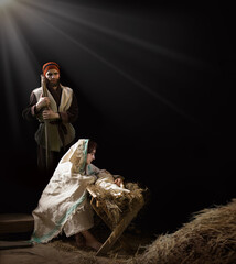 Mary sits in the stable near the manger with the baby