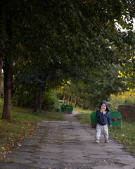Fototapeta premium A little boy runs to the camera in the park. a beautiful child walks along the path in the park.