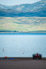 tractor and boat on shore of lake