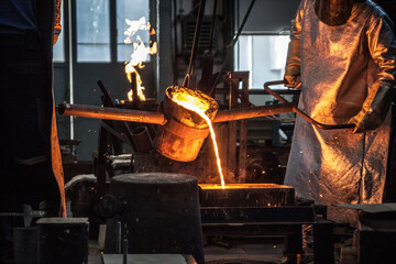 Workers in a foundry safely casting a metal workpiece